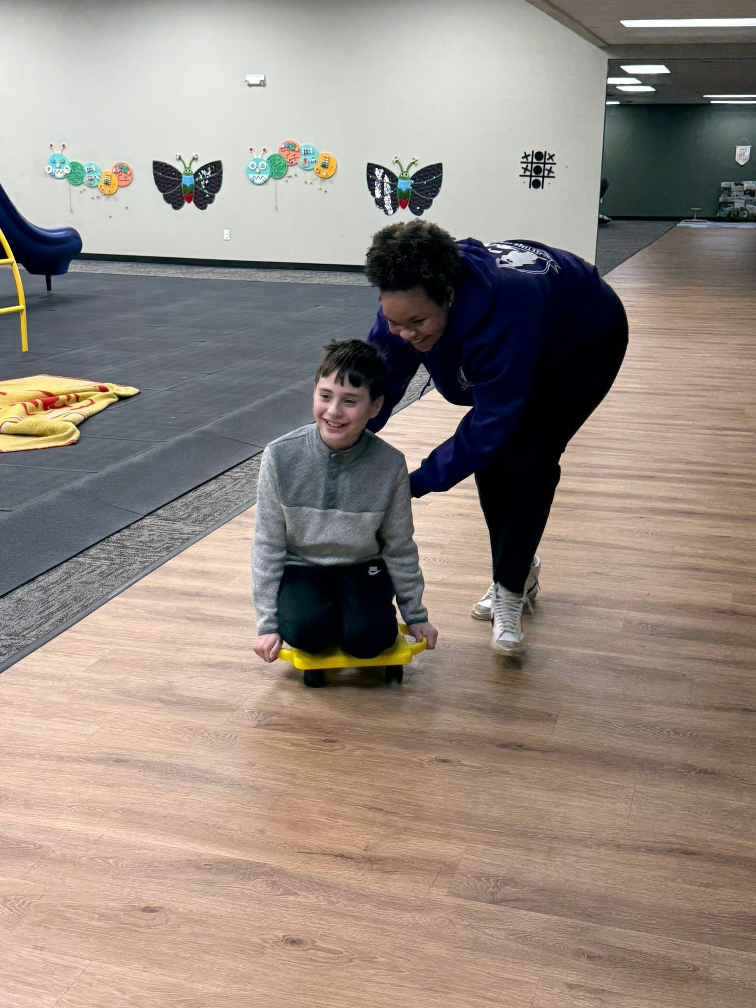 Discovery Program participant engaged in a puppet activity with staff member, building social and communication skills